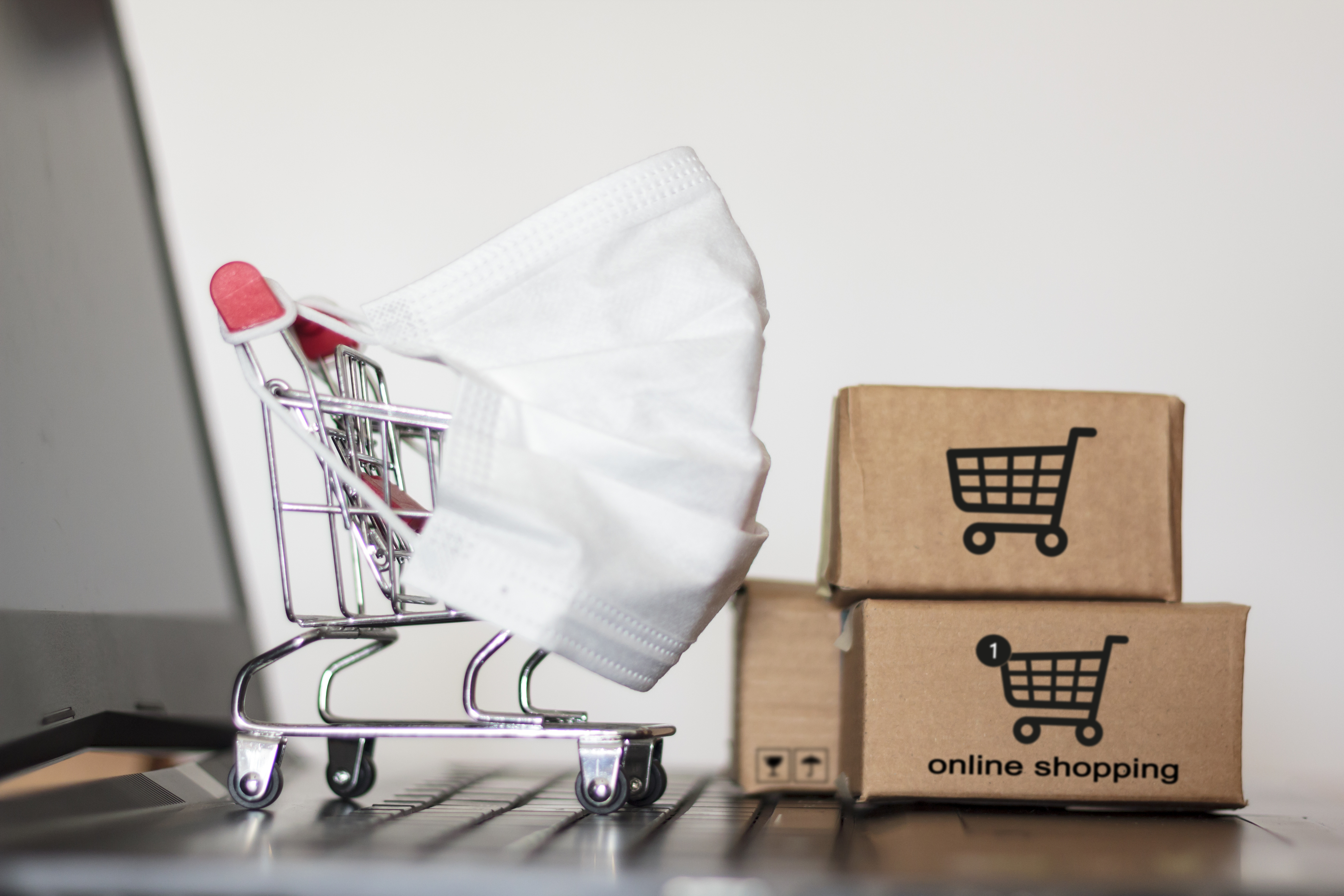 Shopping cart and carton boxes on laptop