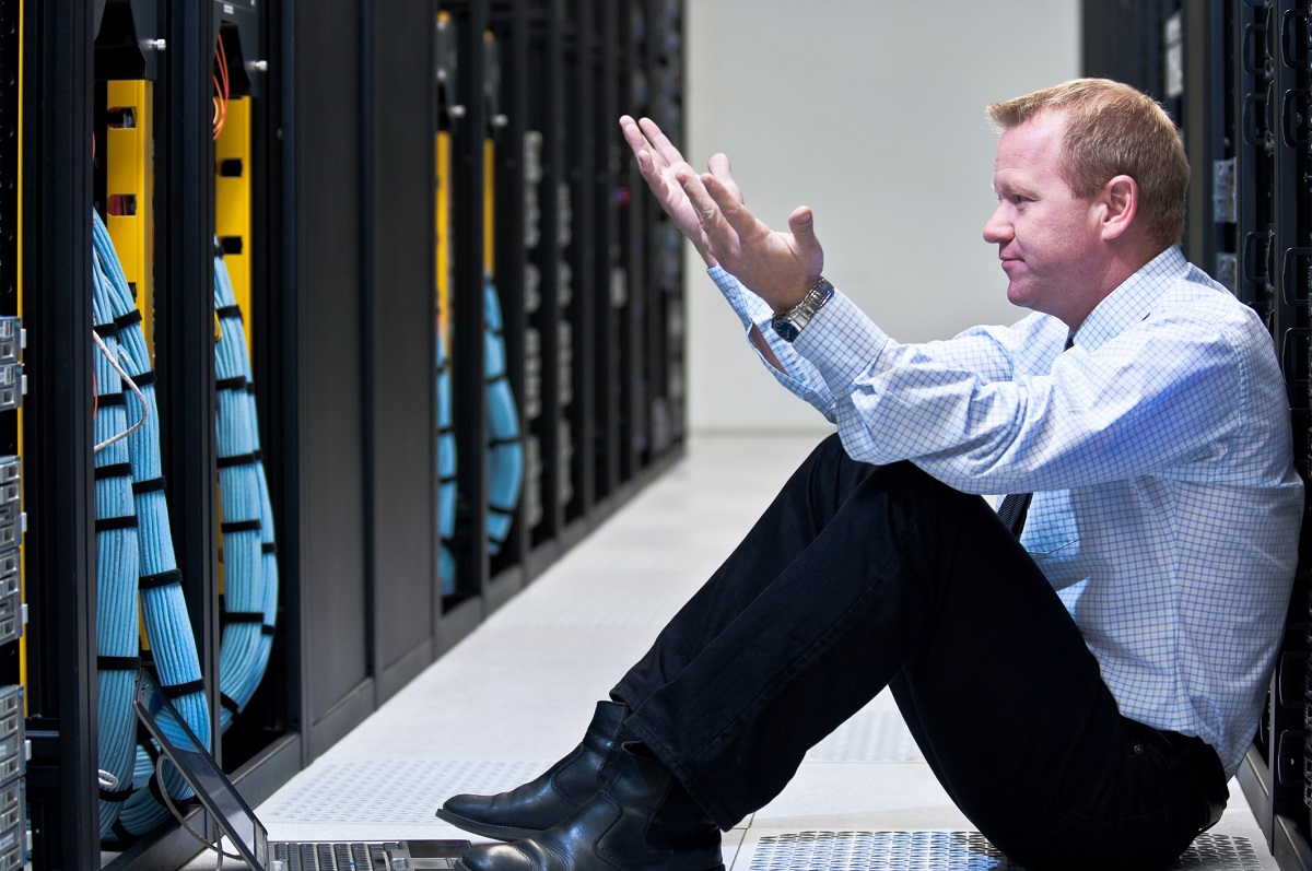 Frustrated businessman staring at row of servers