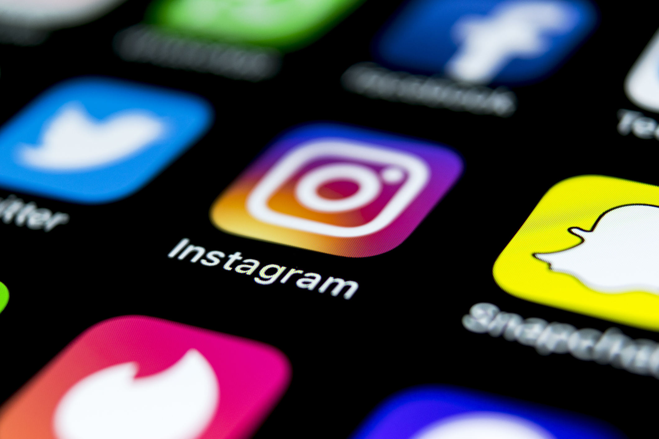 Apple iPhone X on office desk with icons of social media network instagram application on screen. Social network. Starting social media app.