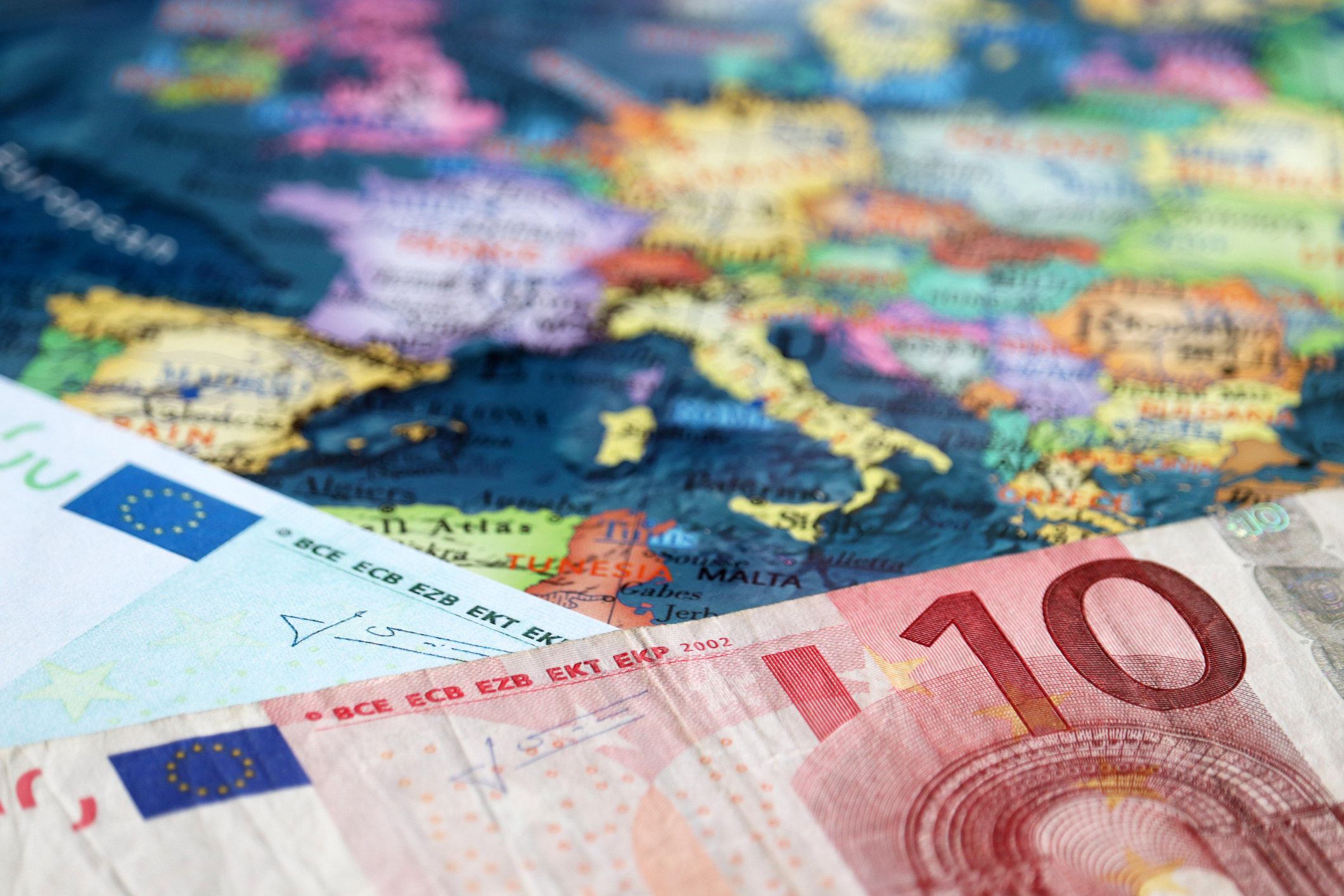 Euro banknotes on the map of Europe, selective focus. Concept for european economy, eurozone countries